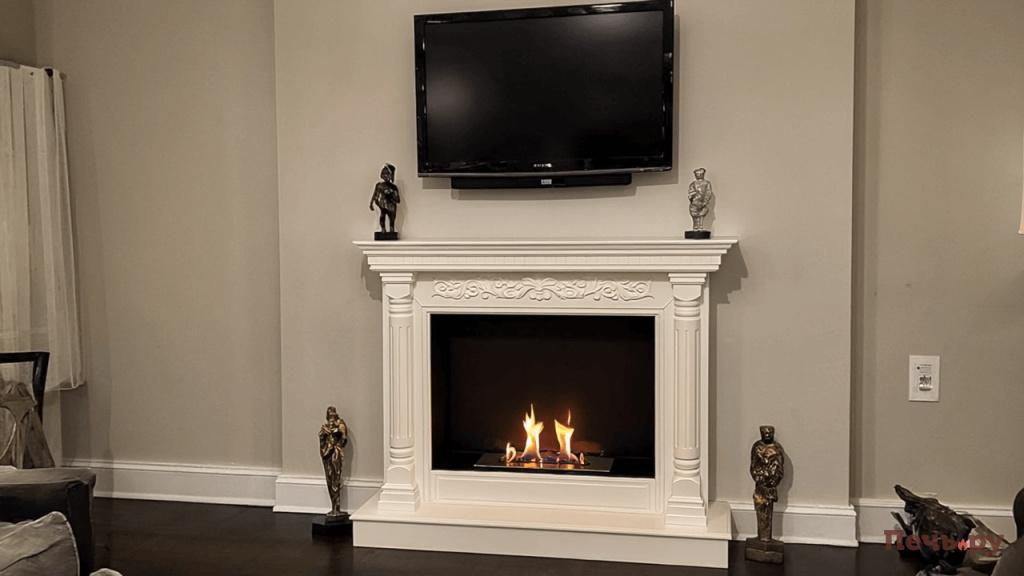 Gen4 биокамин стоит в гостиной у стены над ним висит телевизор и стоят статуэтки 3101957705 (1) (1).jpg